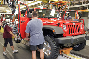 DaimlerChrysler assembly line workers put doors on the Jeep Wrangler at the DaimlerChrysler Toledo Supplier Park in Toledo, Ohio [File: Bill Pugliano/Getty Images]