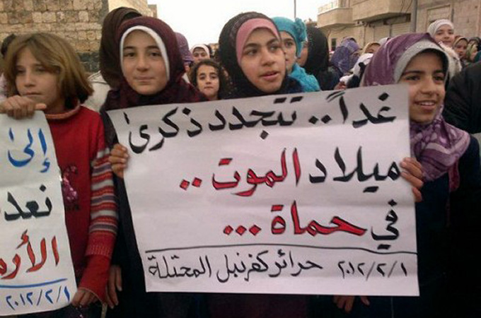 While people in the city could not express themselves, others in more active provinces, like Idlib, referenced it as an example of regime brutality. Shown here, protesters with a sign: ‘Tomorrow we shall remember the anniversary of the death in Hama’, February 1, 2012, as rallies across Syria marked 30 years since the massacre [AFP]