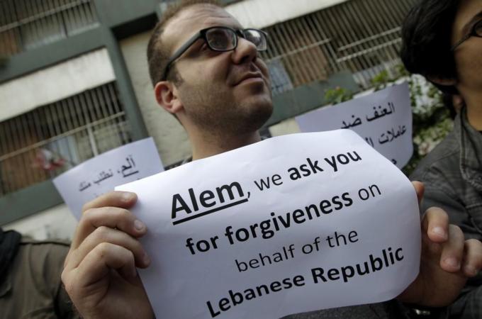 A Lebanese activist holds a sign in refe