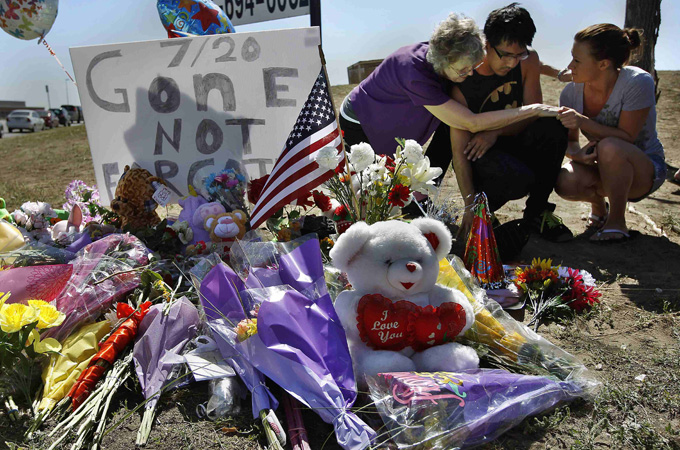 Isaac Pacheco, centre, is comforted after leaving a birthday card for his friend Alex Sullivan, who was killed in the Denver-area movie killings, July 21, 2012