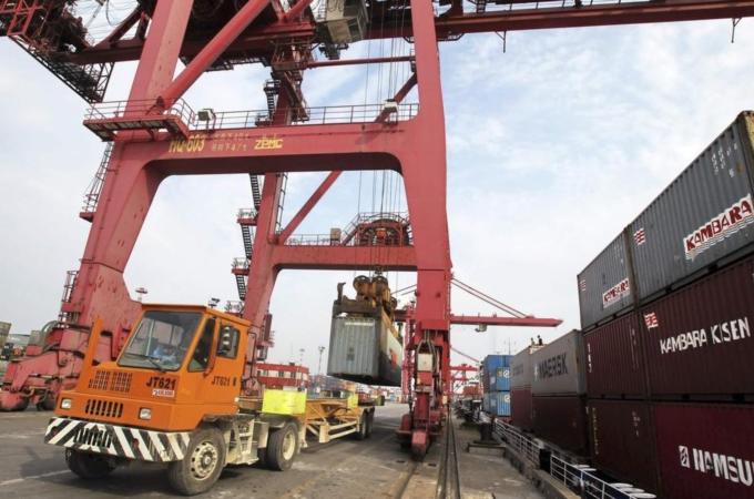 A truck is loaded with a shipping container at a port in Nantong