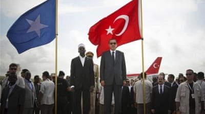Turkey''s PM Erdogan and Somalia''s President Ahmed stand in front of their countries'' national flags as they listen to the national anthems in Mogadishu