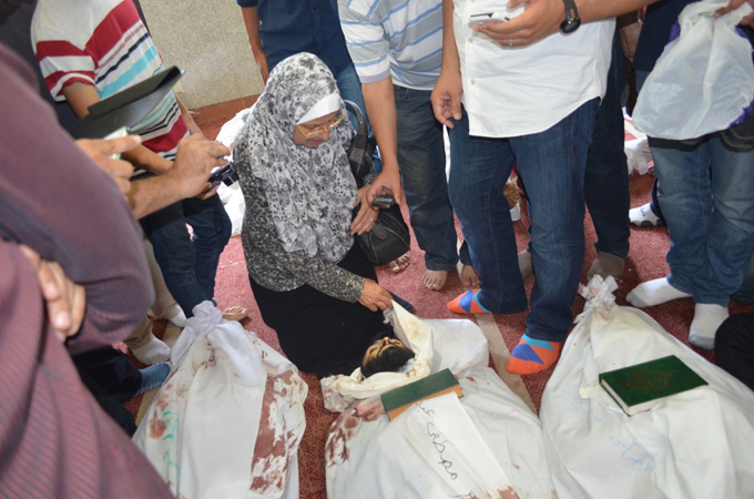 Amir's mother identifies her son among the bodies at a makeshift morgue [Ahmed Bedier/Al Jazeera]