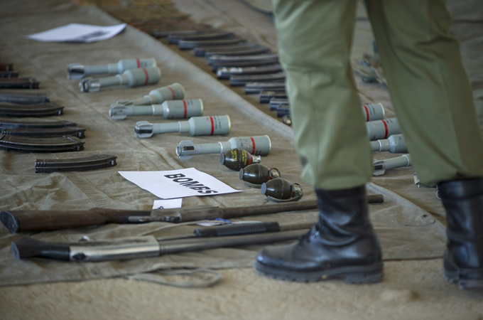 A soldier stands near weapons seized from police and displayed at a barracks in the capital Maseru [AFP]