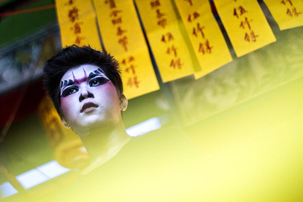 A Chinese opera performer waits on the stage before the show.