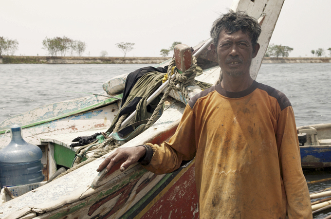 Squatter fishermen such as Benjol are threatened by sinking ground and rising Jakarta waters