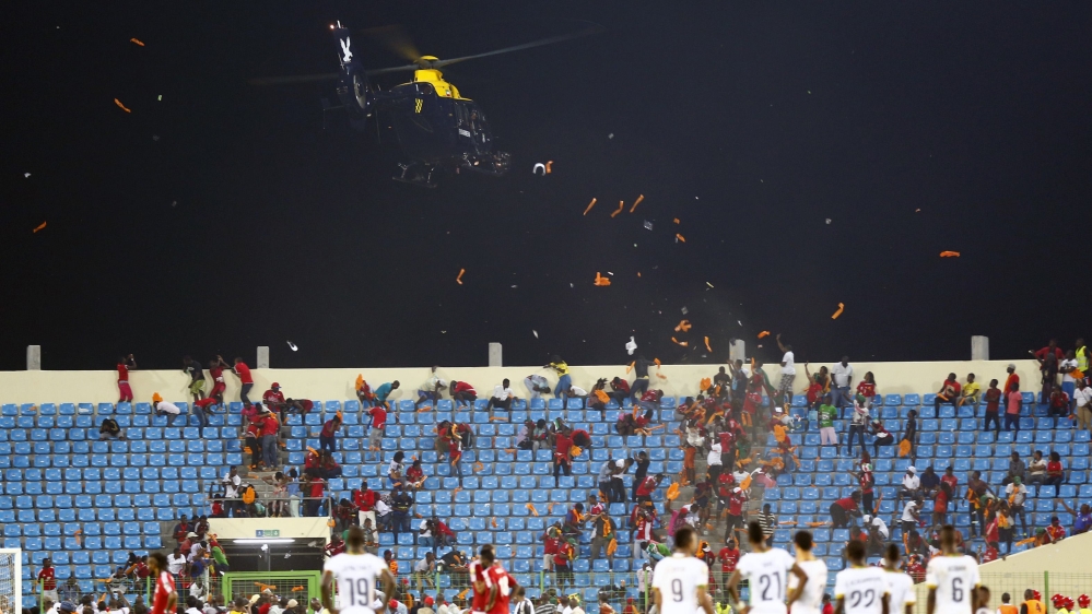 A police helicopter hovers over Equitorial Guinea fans as they throw objects during the 2015 African Cup of Nations semi-final soccer match against Ghana in Malabo