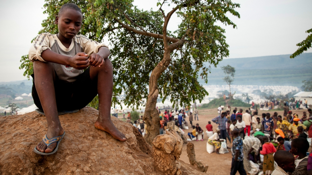 A teenager sits on high ground in the Mahama refugee camp in southeast Rwanda. He fled eastern Burundi in April with his uncle after hearing that