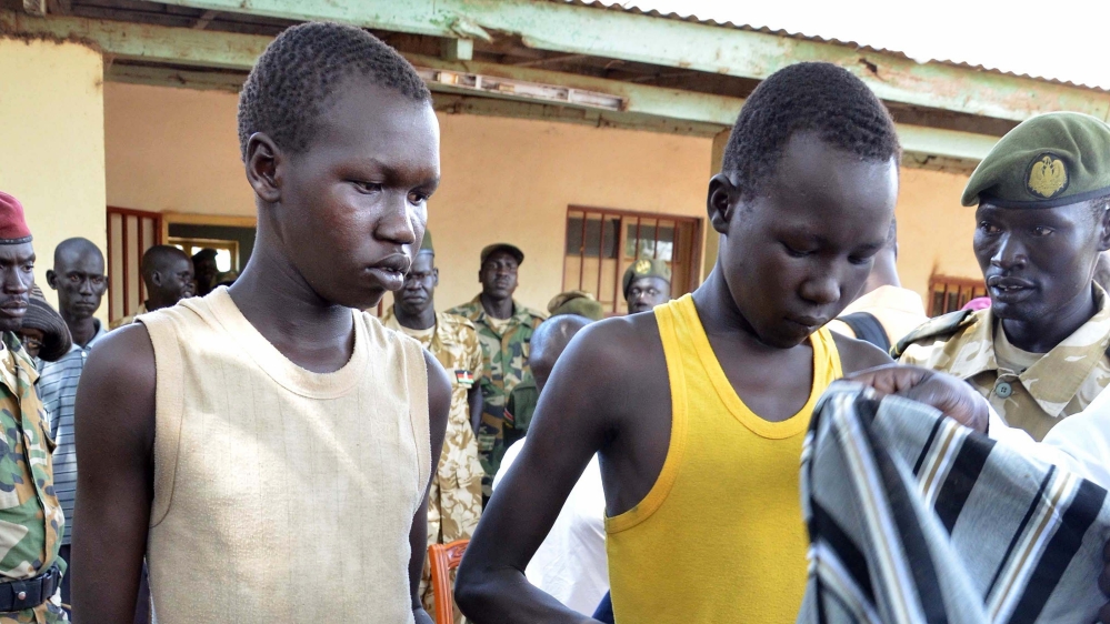 Two child soldiers leave their uniforms during a ceremony of disarmament in Juba, South Sudan [Getty]