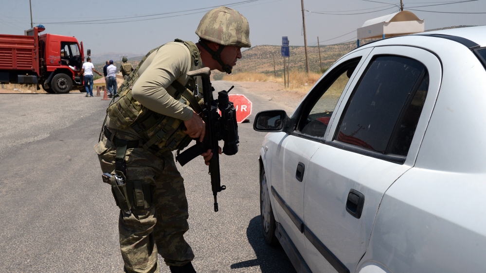 A Turkish soldier checks cars at a checkpoint in Diyarbakir on July 26, 2015 following the death of two
