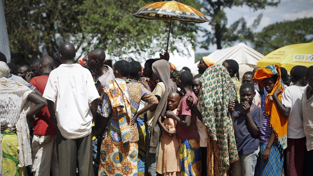 Burundian refugees queue to receive handout clothes from the UNHCR in a refugee camp in Gashora, Rwanda