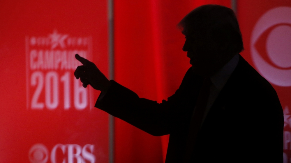 Republican U.S. presidential candidate businessman Donald Trump speaks to someone offstage during a commercial break at the Republican U.S. presidential candidates debate sponsored by CBS News and