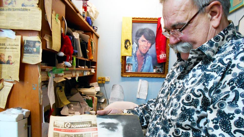 Cote holds a Cuban newspaper from 1975. He says a Canadian spy who had lived in Cuba gave it to him, with a signed photo of Fidel Castro [Andreanne Williams/Al Jazeera]