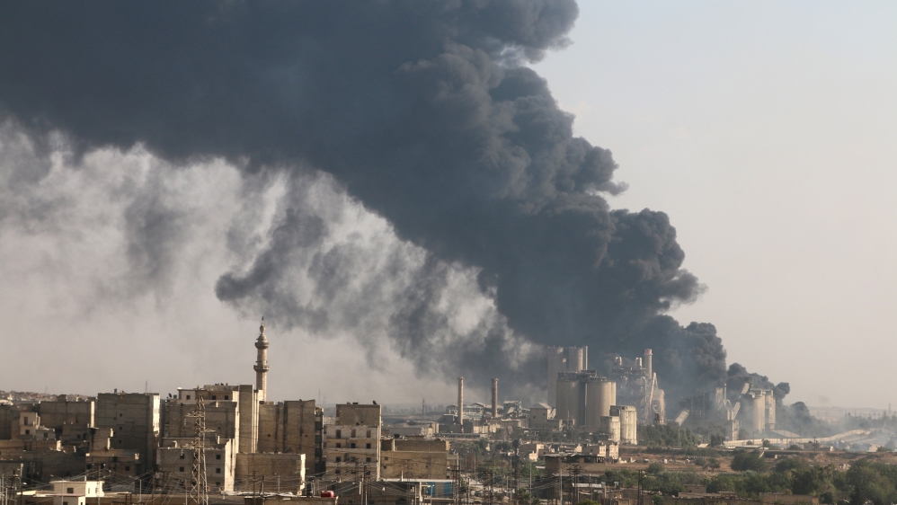 A general view shows rising smoke from a Syrian regime controlled cement factory, in Aleppo