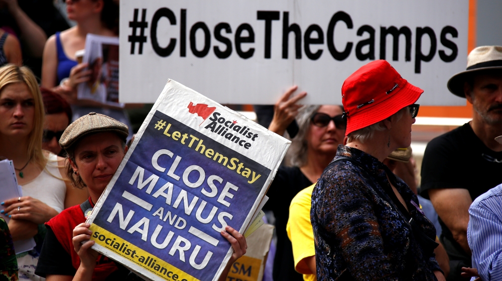 Protesters from the Refugee Action Coalition hold placards during a demonstration outside the offices of the Australian Government Department of Immigration and Border Protection in Sydney, Australia