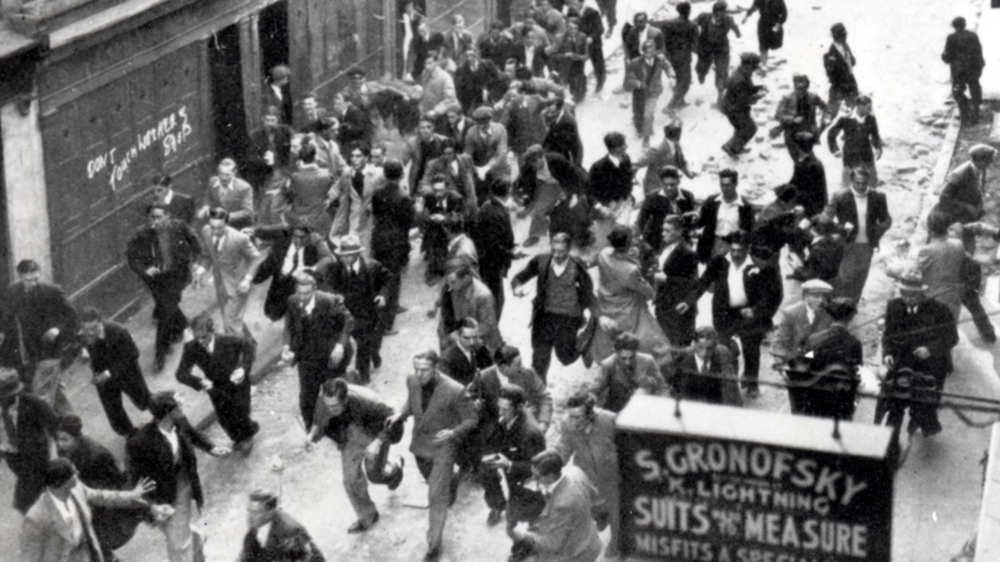 An anti-Fascist crowd run from a barricade they have erected near Aldgate. The police are charging on the far side of the barricade [Jewish Chronicle/Heritage Images/Getty Images]