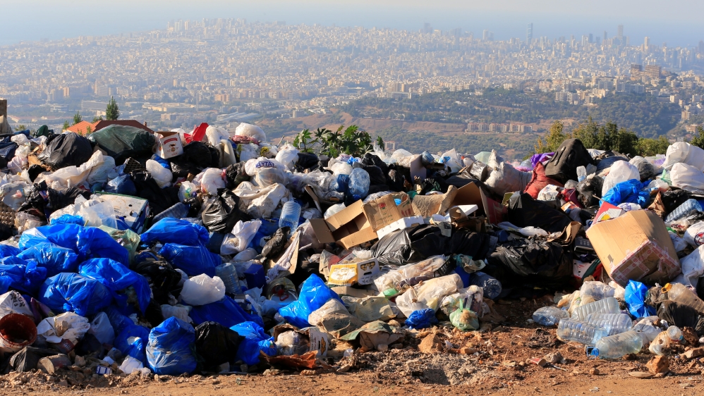 Piled garbage bags are seen in Ain Anoub village overlooking the city of Beirut