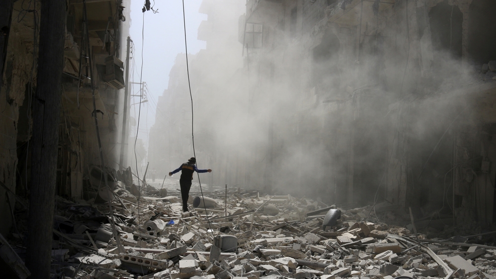 A man walks on the rubble of damaged buildings after an airstrike on the rebel held al-Qaterji neighbourhood of Aleppo