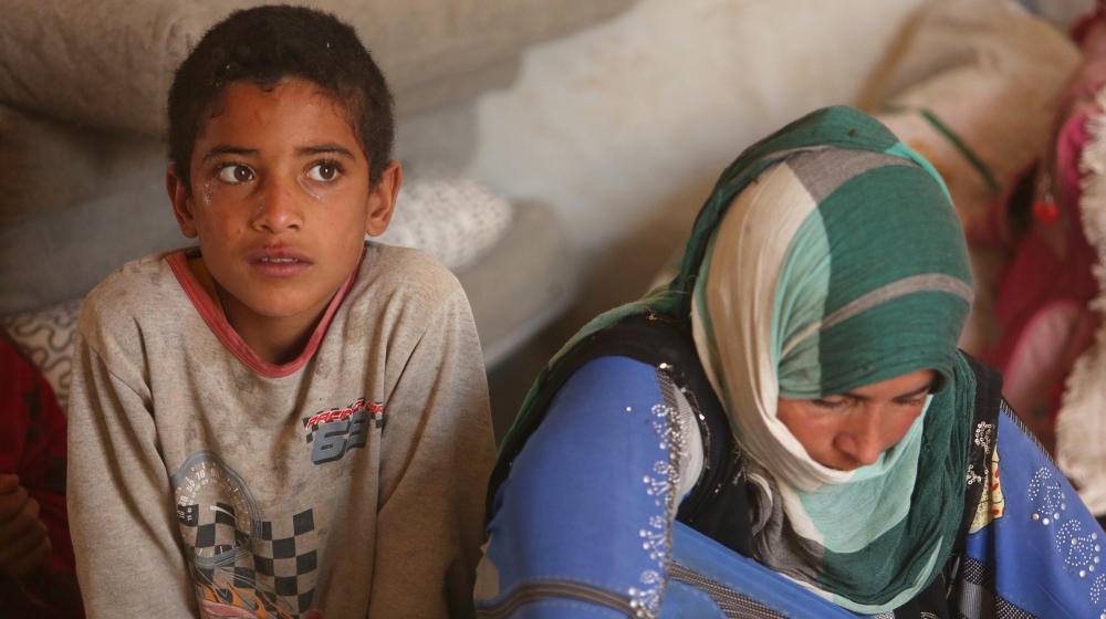 Displaced people who fled Mosul sit inside a tent at a refugee camp in Duhok