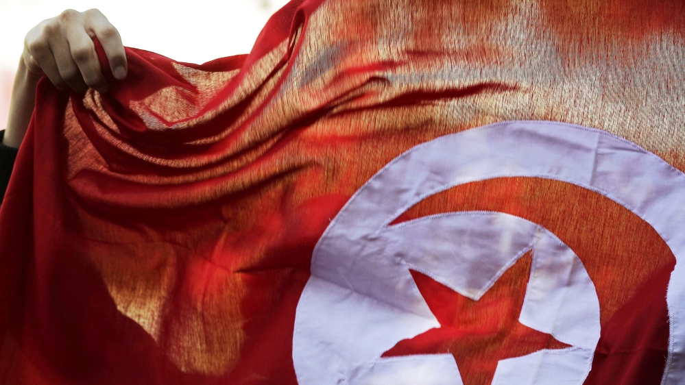 File photo of a person holding up a Tunisian flag and shouts slogans during celebrations marking the fourth anniversary of Tunisia''s 2011 revolution, in Habib Bourguiba Avenue in Tunis
