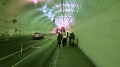 The volunteer counting team walks through an underpass, marking down the number of people sleeping there [Carla Green/Al Jazeera]