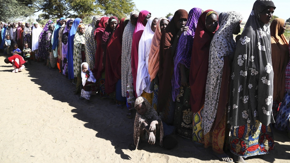Women who have fled violence in Nigeria queue for food at a refugee welcoming center in Ngouboua