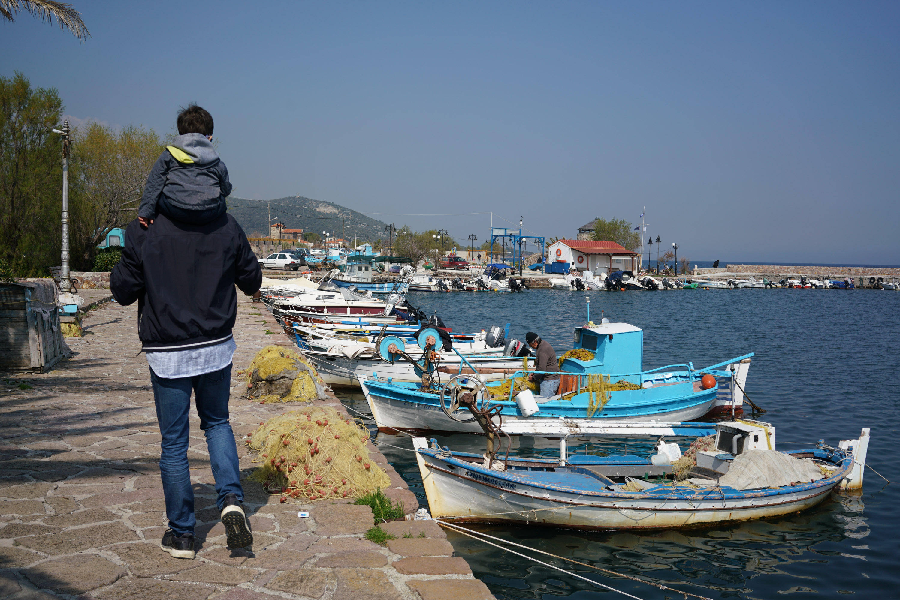 Dimitrios and his two-year-old son Efthimios walk every day around Thermis harbour. Thermis is home to 900 Greeks and 50 refugees [Talitha Brauer/Al Jazeera]
