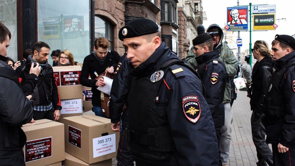 Russian policemen surround Russian gay-rights activists standing next to boxes alledgedly containing signed petitions calling for a probe into a reported crackdown on Chechnya''s LGBT community