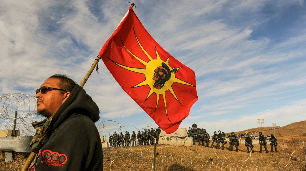 A protesters flies a flag during a stand off with police during a protest of the Dakota Access pipeline near the Standing Rock Indian Reservation near Cannon Ball, North Dakota