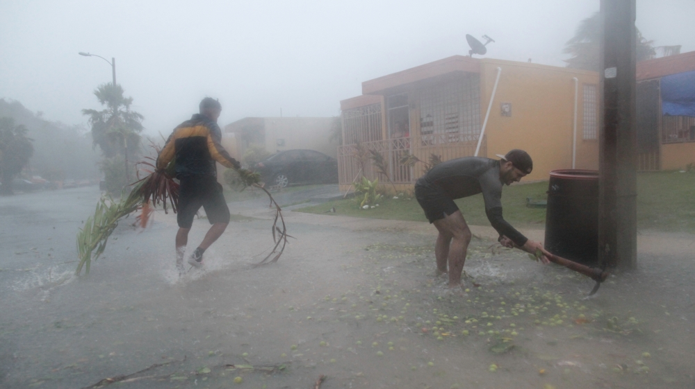 People pick up debris as Hurricane Irma howled past Puerto Rico after thrashing several smaller Caribbean islands, in Fajardo