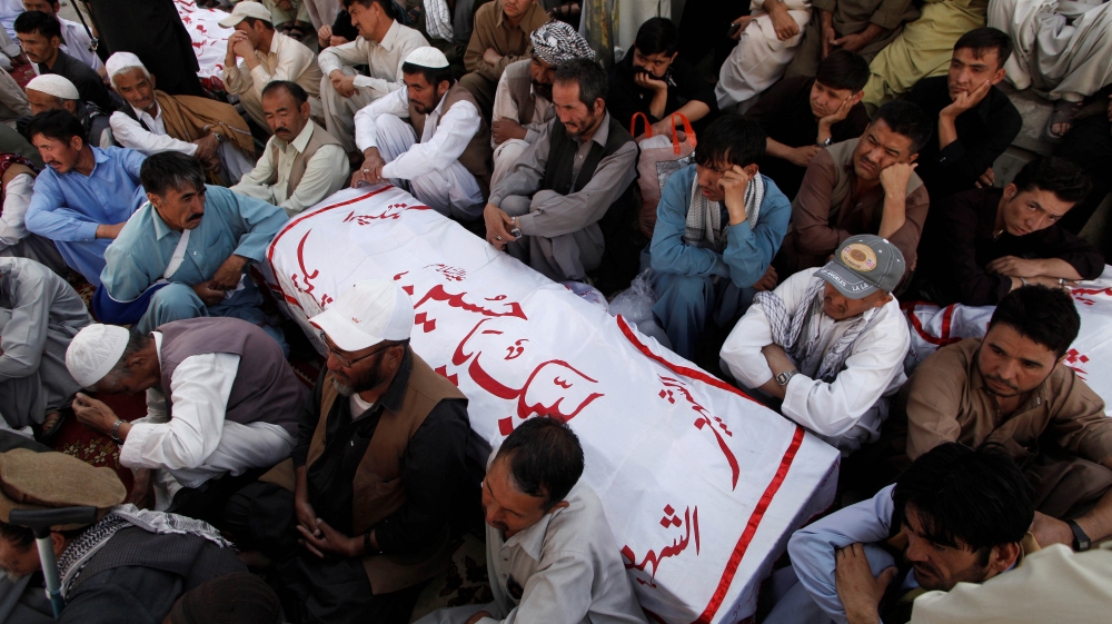 Shi''ite Muslim men from Pakistan''s ethnic Hazara minority mourn around the coffins of their relatives, who were killed in a shooting attack, in Quetta, Pakistan October 9, 2017. REUTERS/Naseer Ahmed