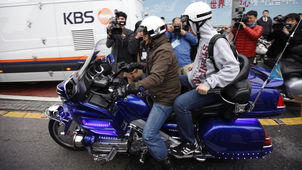 Students are offered a lift by volunteer policemen to ensure they get to the examination centres on time [Kim Hong-Ji/Reuters]