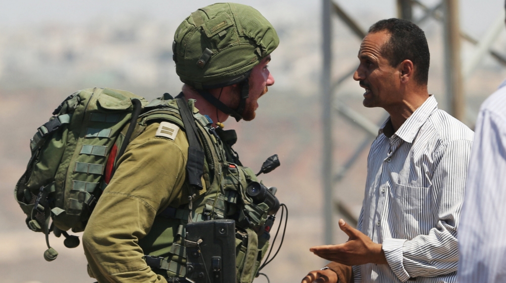 Palestinian man argues with an Israeli soldier during clashes near the West Bank village of Qusra west of Nablus