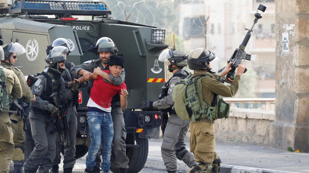 Israeli border policemen detain a Palestinian protester at a demonstration in support of Palestinian prisoners on hunger strike in Israeli jails, in the illegally occupied West Bank town of Bethlehem