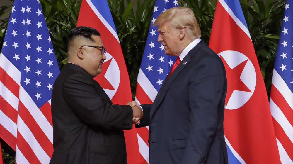 Trump and Kim shake hands at the Capella resort on Sentosa Island [Evan Vucci/The Associated Press]