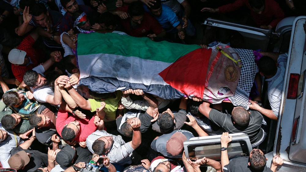 Razan's medical vest was draped over her body during her funeral in Khan Younis [Hossam Salem/Al Jazeera] 