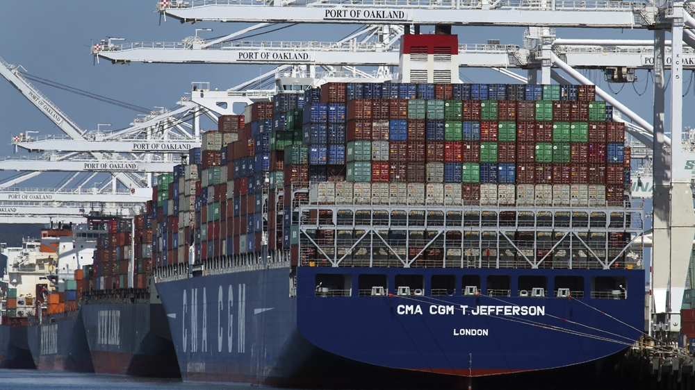 FILE- In this May 21, 2018, file photo, container ships are unloaded at the Port of Oakland in Oakland, California
