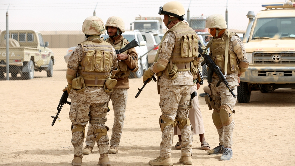 Saudi troops stand at an airfield, where Saudi cargo planes delivered aid, in the northern province of Marib
