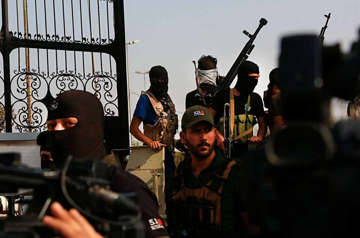 Popular Mobilization Forces parade in Basra, 340 miles (550 km) southeast of Baghdad, Iraq, Saturday, Sept. 8, 2018. A local military commander for an alliance of powerful Shiite militias, many of the
