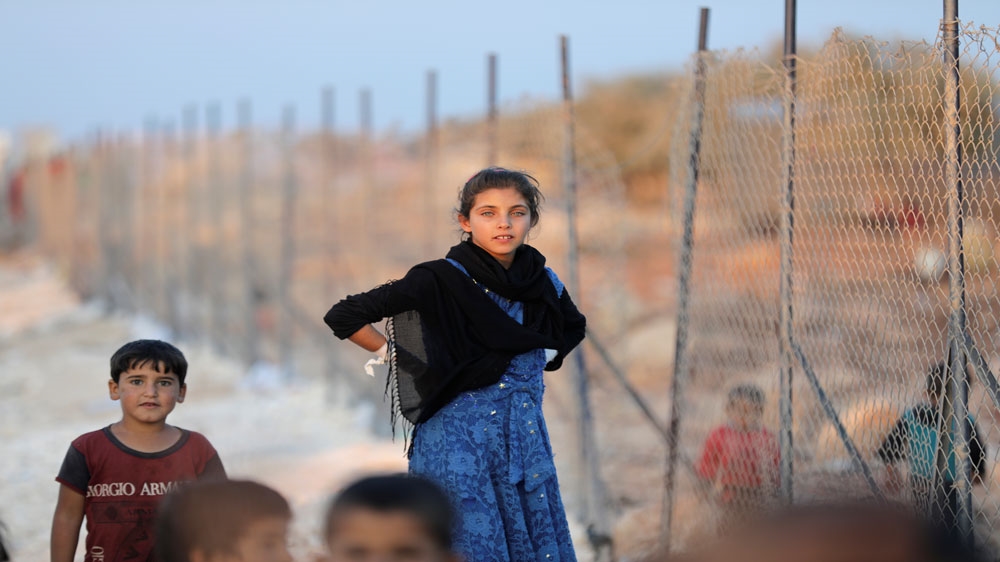 Displaced Syrian children arrive at a refugee camp in Atimah village, Idlib, in September [File: Khalil Ashawi/ Reuters]