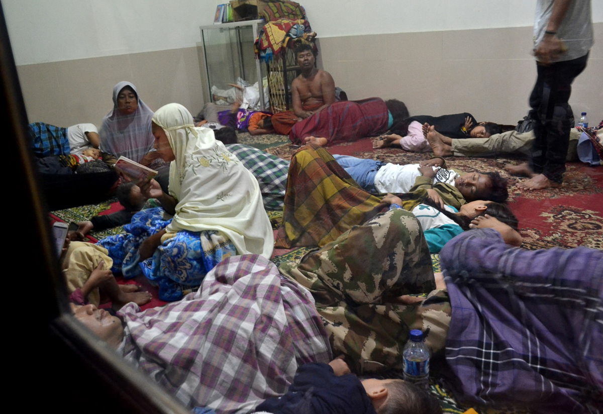 Residents sit inside a mosque as they evacuated following high waves and the eruption of Anak Krakatau volcano at Labuan district in Pandeglang regency, Banten province, Indonesia, December 22, 2018 i