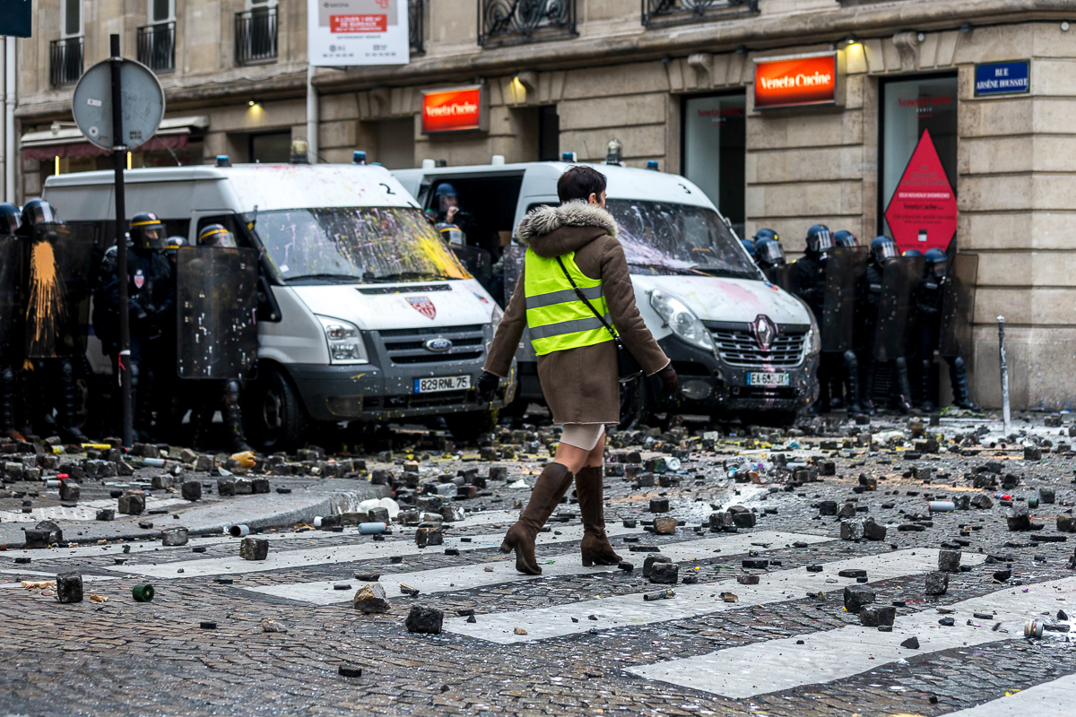 A protester walks in front of a group of police forces on a street adjacent to the Champs ElysE`es during a protest called by the i`Gilets Jaunesi´ on December 01, 2018 in Paris, France. Photo by Oma