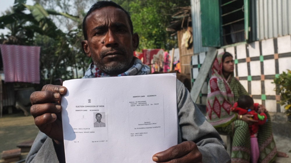 Bodiot Zaman shows a copy of the identity card of his trapped son Abdul Kalam Sheikh [Priyanka Borpujari/Al Jazeera]