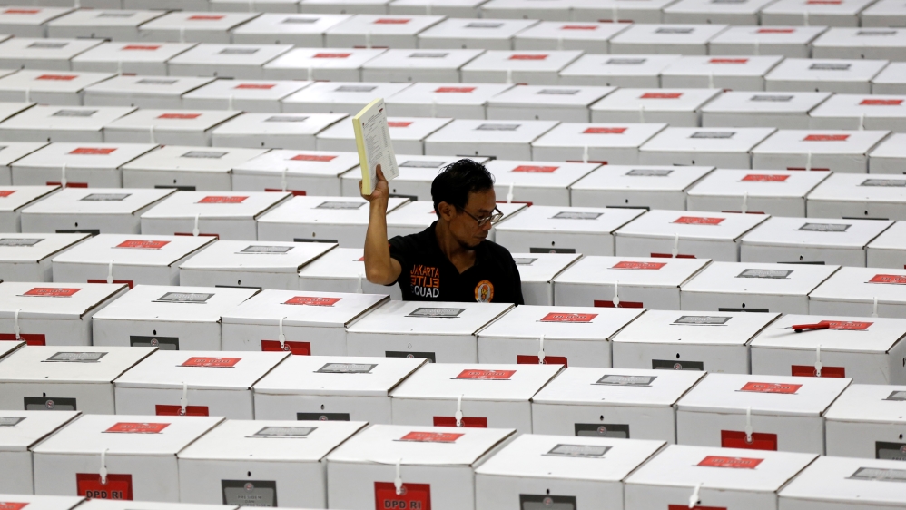 A worker carries election materials as he prepares ballot boxes before their distribution to polling stations in a warehouse in Jakarta, Indonesia, April 15, 2019. REUTERS/Willy Kurniawan
