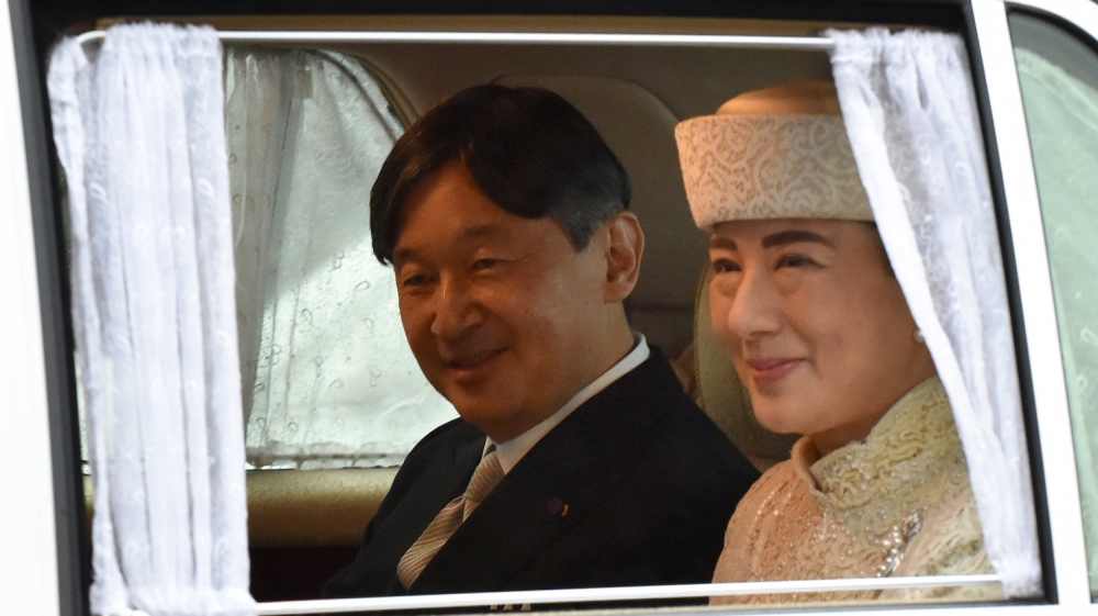 A vehicle carrying Crown Prince Naruhito (L) and Crown Princess Masako (R) leaves the Imperial Palace in Tokyo on April 30, 2019.