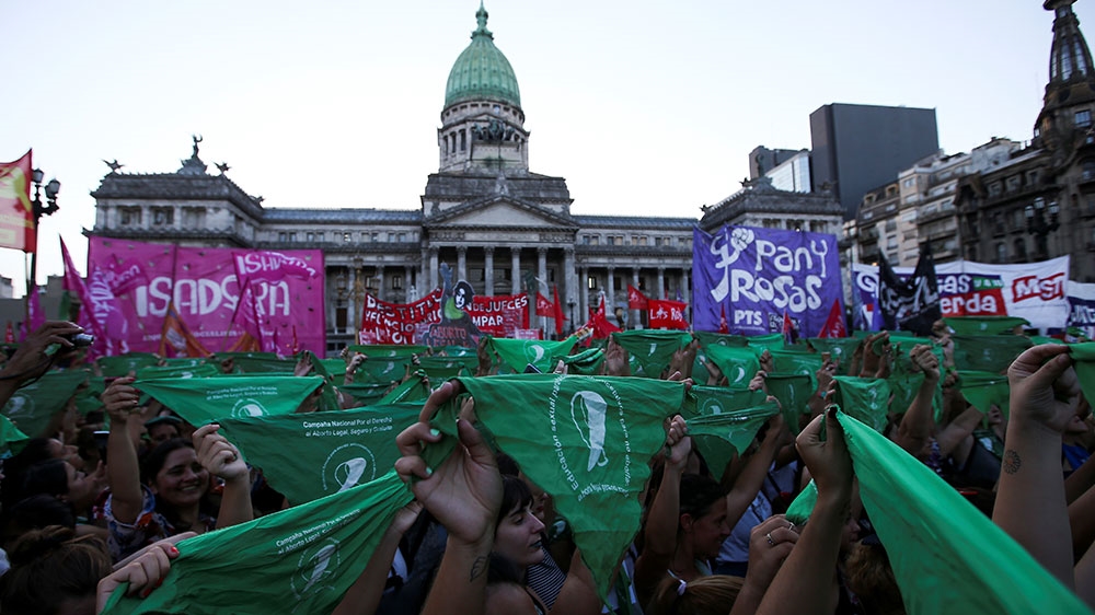 Activists hold up green handkerchiefs, which symbolise the abortion rights movement, outside the National Congress in Buenos Aires, Argentina