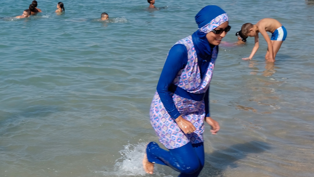 A woman wearing a burkini walks in the water August 27, 2016 on a beach in Marseille, France, the day after the country''s highest administrative court suspended a ban on full-body burkini swimsuits t