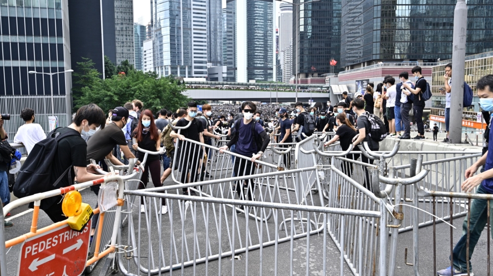 Protester use cable ties to lock barricades near the government headquarters in Hong Kong