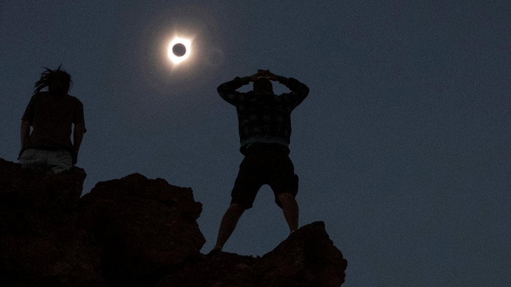 Enthusiasts watch a total solar eclipse while standing atop Carroll Rim Trail at Painted Hills, near Mitchell, Oregon in 2017