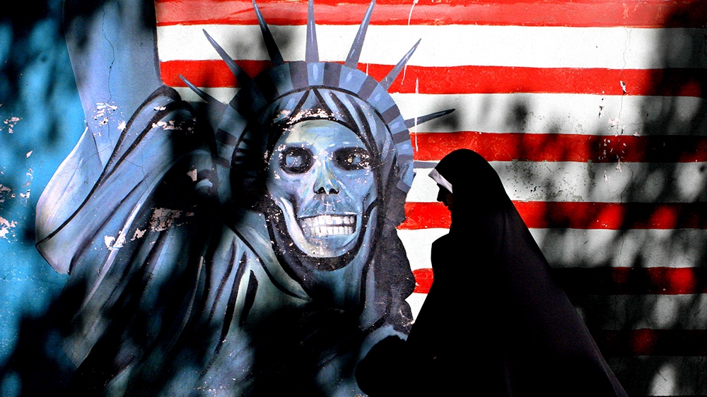 FILE - In this Sept. 25, 2007, file photo, an Iranian woman walks past graffiti art characterizing the U.S. Statue of Liberty, painted on the wall of the former U.S. Embassy in Tehran, Iran. The famil